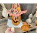 A handmade Halloween decoration, a fall gourd carved into a whimsical pumpkin. This pumpkin comes with a battery-operated candle. 